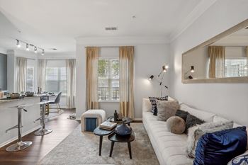 a living room with a white couch and a bar and a large mirror